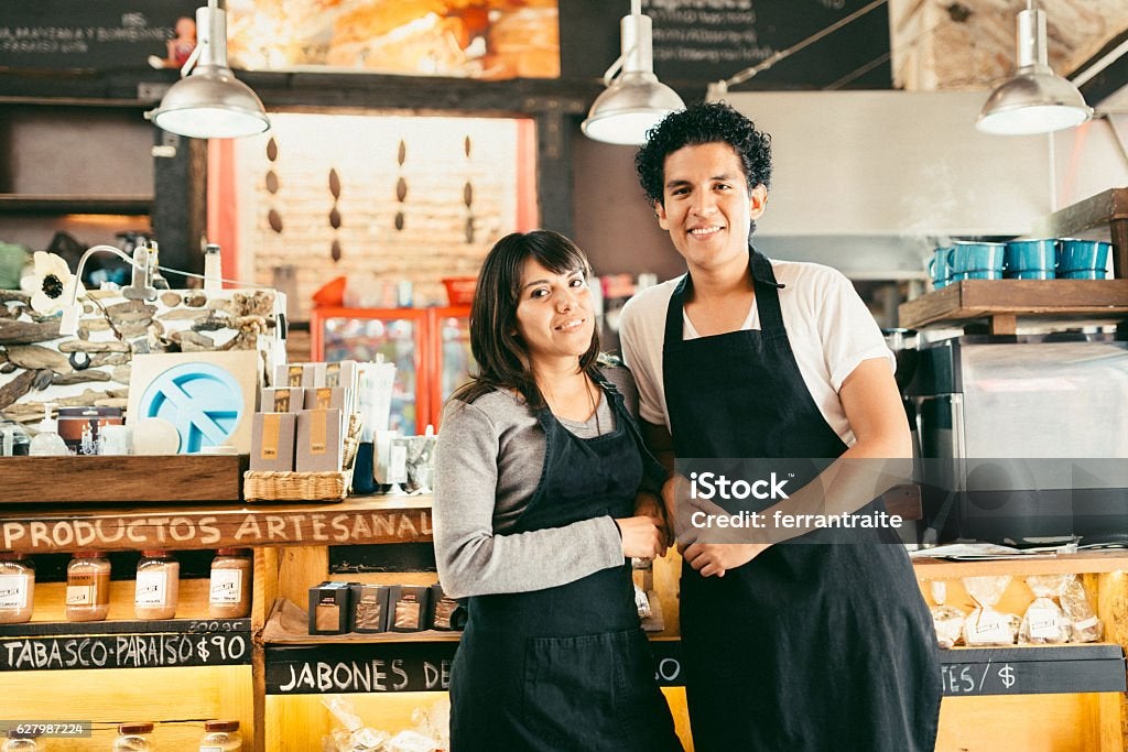 Small Business Owners standing by the counter of his Chocolate and Coffee speciality business.